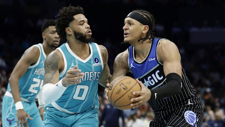 Mar 19, 2026; Charlotte, North Carolina, USA; Orlando Magic forward Paolo Banchero (5) tries to drive to the basket past Charlotte Hornets forward Miles Bridges (0) during the third quarter at Spectrum Center. Mandatory Credit: Brian Westerholt-Imagn Images