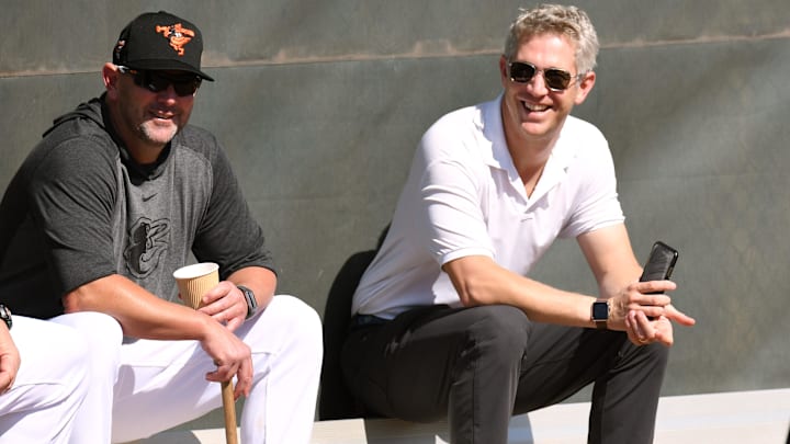 Feb 15, 2020; Sarasota, Florida, USA;  Baltimore Orioles manager Brandon Hyde (18) and Baltimore Orioles  general manager Mike Elias talk during the spring training workout at Ed Smith Stadium.