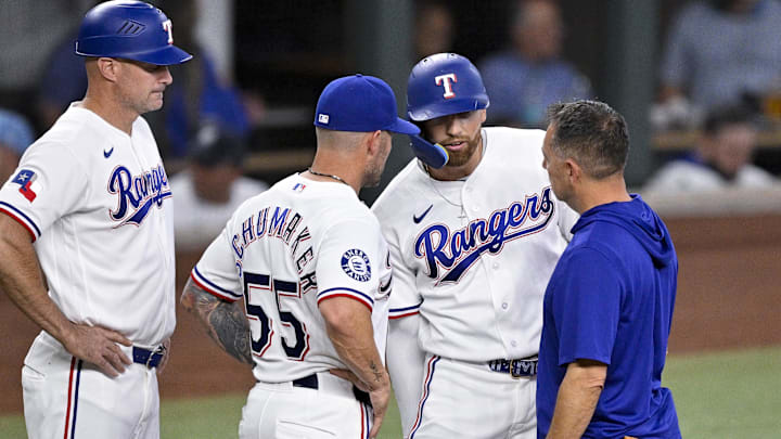 Apr 29, 2026; Arlington, Texas, USA; Texas Rangers manager Skip Schumaker (55) and team staff check on right fielder Brandon Nimmo (24) during the fifth inning against the New York Yankees at Globe Life Field. Mandatory Credit: Jerome Miron-Imagn Images