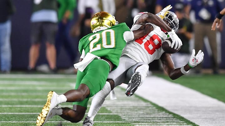 Sep 23, 2023; South Bend, Indiana, USA; Ohio State Buckeyes wide receiver Marvin Harrison Jr. (18) makes a catch as Notre Dame Fighting Irish cornerback Benjamin Morrison (20) defends in the second quarter at Notre Dame Stadium. The catch was reviewed and ruled and incomplete pass and Morrison was given a pass interference penalty. Mandatory Credit: Matt Cashore-Imagn Images Sep 23, 2023; South Bend, Indiana, USA; Ohio State Buckeyes wide receiver Marvin Harrison Jr. (18) makes a catch as Notre Dame Fighting Irish cornerback Benjamin Morrison (20) defends in the second quarter at Notre Dame Stadium. The catch was reviewed and ruled and incomplete pass and Morrison was given a pass interference penalty. Mandatory Credit: Matt Cashore-Imagn Images