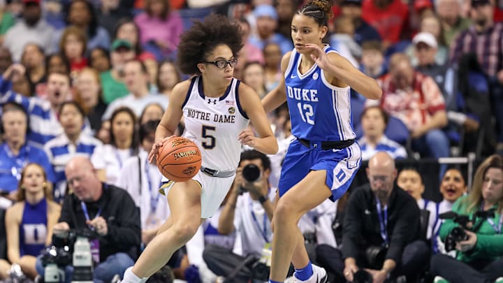 Mar 8, 2025; Greensboro, NC, USA; Notre Dame Fighting Irish guard Olivia Miles (5) moves the ball around Duke Blue Devils forward Delaney Thomas (12) during the first quarter at First Horizon Coliseum. Mar 8, 2025; Greensboro, NC, USA; Notre Dame Fighting Irish guard Olivia Miles (5) moves the ball around Duke Blue Devils forward Delaney Thomas (12) during the first quarter at First Horizon Coliseum.