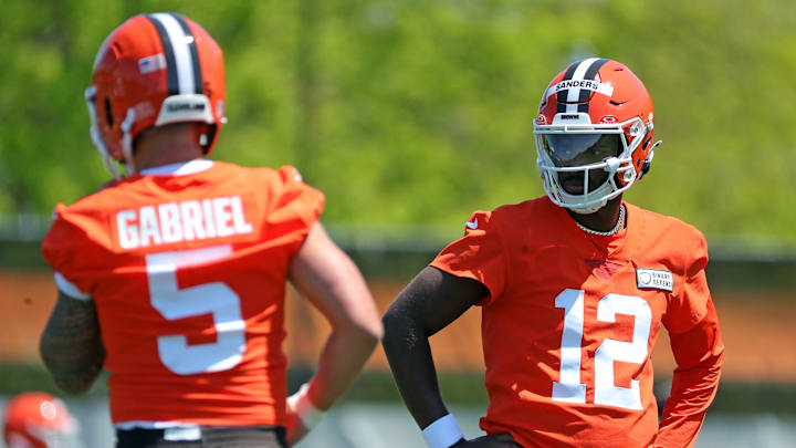Cleveland Browns quarterback Shedeur Sanders (12) watches quarterback Dillon Gabriel (5) during day two of NFL rookie minicamp at the Cleveland Browns training facility on Saturday, May 10, 2025, in Berea, Ohio.