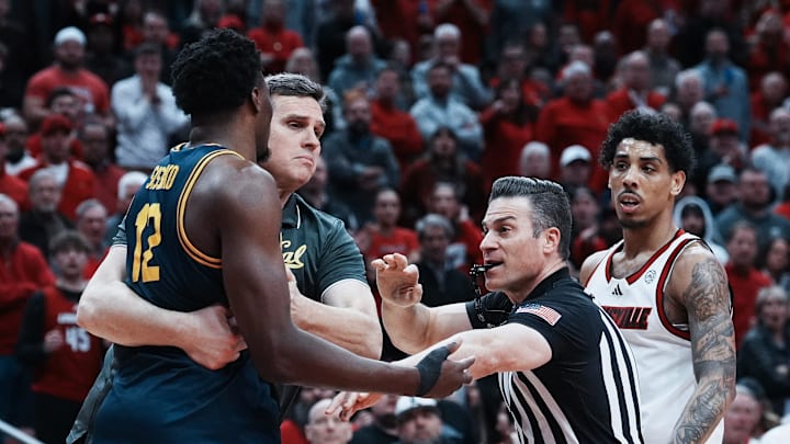 Cal head coach Mark Madsen held back Mady Sissoko after Sissoko was tripped by Louisville guard Terrence Edwards Jr. (right) Cal head coach Mark Madsen held back Mady Sissoko after Sissoko was tripped by Louisville guard Terrence Edwards Jr. (right)