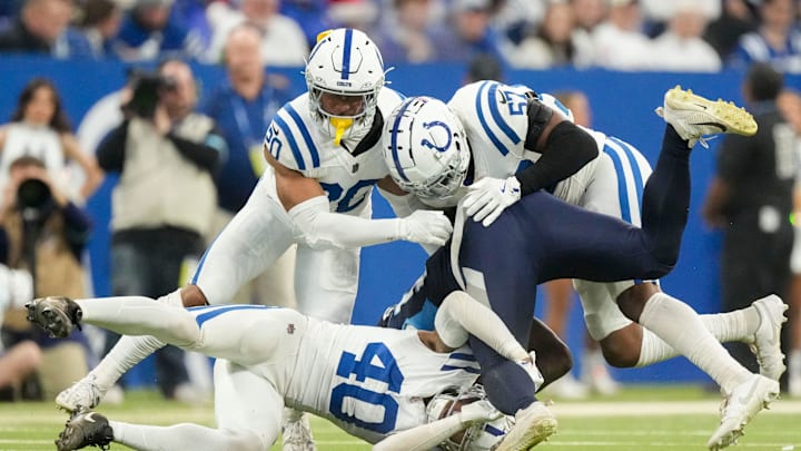 Tennessee Titans tight end Chig Okonkwo (85) is tackled by Indianapolis Colts safety Nick Cross (20), Indianapolis Colts linebacker Jaylon Carlies (57) and Indianapolis Colts cornerback Jaylon Jones (40) on Sunday, Dec. 22, 2024, during a game against the Tennessee Titans at Lucas Oil Stadium in Indianapolis.