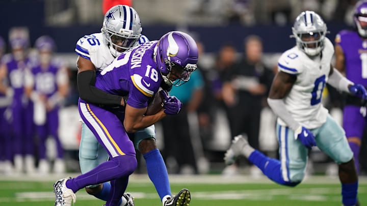 Dec 14, 2025; Arlington, Texas, USA; Dallas Cowboys cornerback Daron Bland (26) tackles Minnesota Vikings wide receiver Justin Jefferson (18) during the first half at AT&T Stadium. 