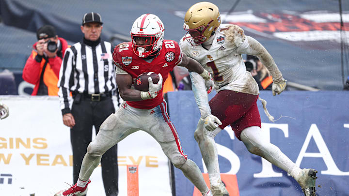 Dec 28, 2024; Bronx, NY, USA; Nebraska Cornhuskers running back Emmett Johnson (21) scores a touchdown as Boston College Eagles linebacker Daveon Crouch (1) defends during the second half at Yankee Stadium. Mandatory Credit: Vincent Carchietta-Imagn Images