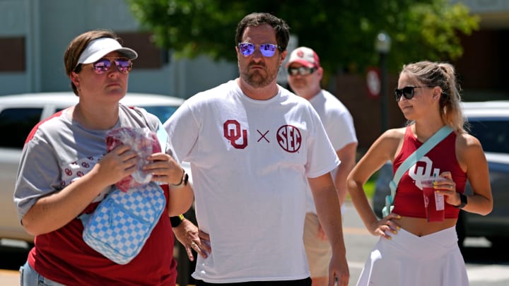 A fan wearing an SEC shirt watches as members of the OU band and the spirit squad perform at Campus Corner during a celebration for OU joining the Southeastern Conference in Norman, Okla., Monday, July 1, 2024.