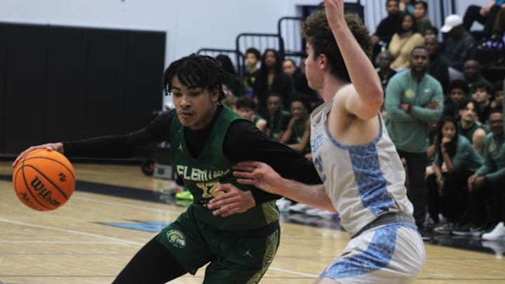 Fleming Island forward Carson Crawford (12) dribbles into the lane as Ponte Vedra forward Tyler Cowan (21) defends during an FHSAA District 3-6A high school boys basketball semifinal on February 8, 2024. [Clayton Freeman/Florida Times-Union]