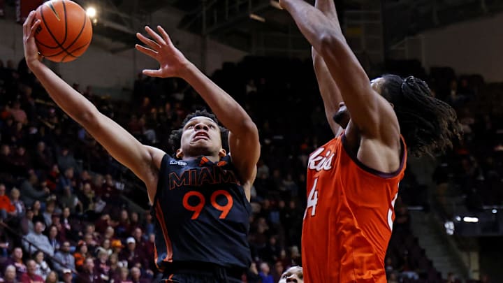 Jan 4, 2025; Blacksburg, Virginia, USA; Miami Hurricanes guard Divine Ugochukwu (99) shoots the ball against Virginia Tech Hokies forward Mylyjael Poteat (34) during the second half at Cassell Coliseum. Mandatory Credit: Peter Casey-Imagn Images Jan 4, 2025; Blacksburg, Virginia, USA; Miami Hurricanes guard Divine Ugochukwu (99) shoots the ball against Virginia Tech Hokies forward Mylyjael Poteat (34) during the second half at Cassell Coliseum. Mandatory Credit: Peter Casey-Imagn Images