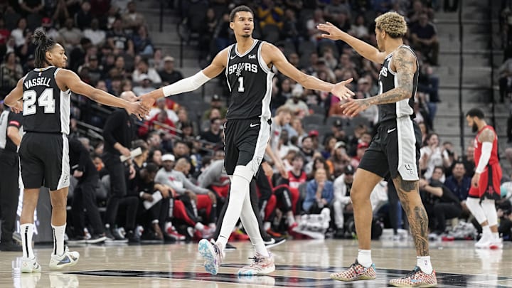 Mar 12, 2024; San Antonio, Texas, USA; San Antonio Spurs forward Victor Wembanyama (1) reacts with guard Devin Vassell (24) and forward Jeremy Sochan (10) before a timeout during the first half against the Houston Rockets at Frost Bank Center. Mandatory Credit: Scott Wachter-Imagn Images