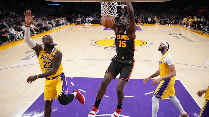Mar 18, 2024; Los Angeles, California, USA; Atlanta Hawks center Clint Capela dunks the ball against Los Angeles Lakers All_Stars LeBron James and Anthony Davis.