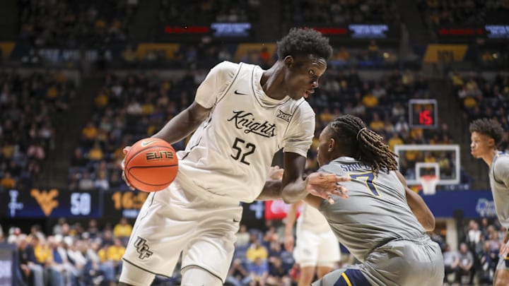 Mar 8, 2025; Morgantown, West Virginia, USA; UCF Knights center Moustapha Thiam (52) makes a move against West Virginia Mountaineers guard Javon Small (7) during the second half at WVU Coliseum. Mandatory Credit: Ben Queen-Imagn Images