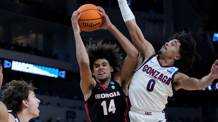 Mar 20, 2025; Wichita, KS, USA; Georgia Bulldogs forward Asa Newell (14) and Gonzaga Bulldogs guard Ryan Nembhard (0) fight for a rebound in the first half of a first round men’s NCAA Tournament game at Intrust Bank Arena. Mandatory Credit: Kirby Lee-Imagn Images