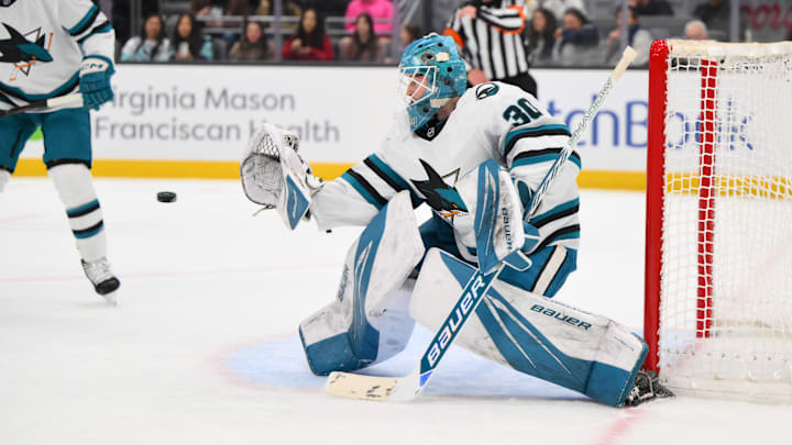 Jan 30, 2025; Seattle, Washington, USA; San Jose Sharks goaltender Yaroslav Askarov (30) deflects a Seattle Kraken goal shot during the first period at Climate Pledge Arena. Mandatory Credit: Steven Bisig-Imagn Images
