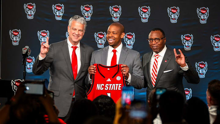 NC State AD Boo Corrigan, men's basketball coach Justin Gainey and Chancellor Kevin Howell pose at Gainey's introductory press conference at the Lenovo Center on Wednesday, April 1, 2026. 