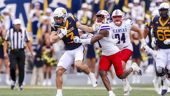 Sep 21, 2024; Morgantown, West Virginia, USA; West Virginia Mountaineers wide receiver Hudson Clement (3) catches a pass and stiff arms Kansas Jayhawks safety O.J. Burroughs (5) during the first quarter at Mountaineer Field at Milan Puskar Stadium. Mandatory Credit: Ben Queen-Imagn Images