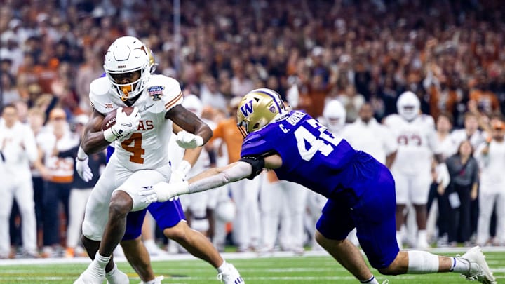 Jan 1, 2024; New Orleans, LA, USA; Texas Longhorns running back CJ Baxter (4) runs with the ball against Washington Huskies linebacker Carson Bruener (42) during the first quarter of the 2024 Sugar Bowl college football playoff semifinal game at Caesars Superdome. Mandatory Credit: Stephen Lew-Imagn Images