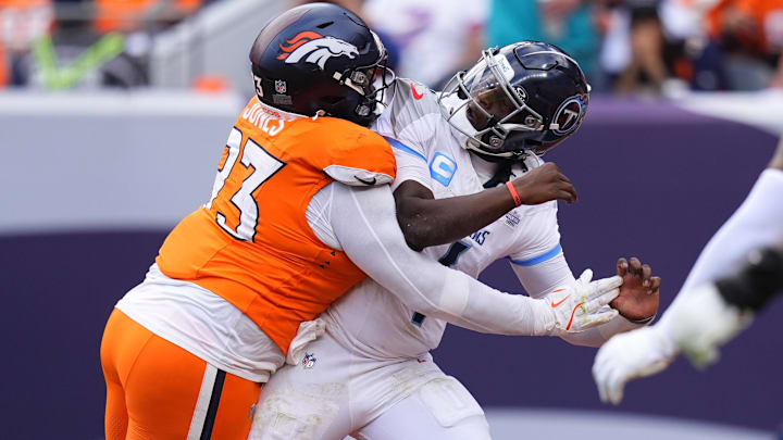 Sep 7, 2025; Denver, Colorado, USA; Denver Broncos defensive tackle D.J. Jones (93) hits Tennessee Titans quarterback Cam Ward (1) in the second half at Empower Field at Mile High. Sep 7, 2025; Denver, Colorado, USA; Denver Broncos defensive tackle D.J. Jones (93) hits Tennessee Titans quarterback Cam Ward (1) in the second half at Empower Field at Mile High.