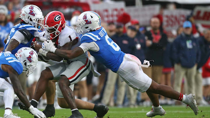 Nov 9, 2024; Oxford, Mississippi, USA; Georgia Bulldogs running back Trevor Etienne (1) runs the ball as Mississippi Rebels linebacker TJ Dottery (6) makes the tackle during the first half at Vaught-Hemingway Stadium. Mandatory Credit: Petre Thomas-Imagn Images