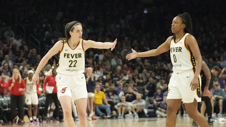Jun 30, 2024; Phoenix, Ariz., U.S.; Indiana Fever guard Caitlin Clark (22) slaps hands with guard Kelsey Mitchell (0) during the third quarter against the Phoenix Mercury at Footprint Center. Mandatory Credit: Michael Chow-Arizona Republic