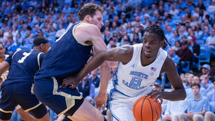 Nov 18, 2025; Chapel Hill, North Carolina, USA; North Carolina Tar Heels forward Caleb Wilson (8) drives on Navy Midshipmen center Aidan Kehoe (99) during the second half at Dean E. Smith Center. Mandatory Credit: Scott Kinser-Imagn Images