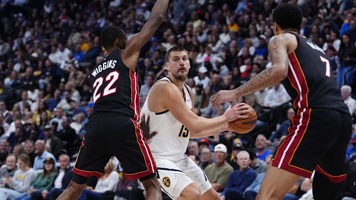 Nov 5, 2025; Denver, Colorado, USA; Miami Heat forward Andrew Wiggins (22) and center Kel'el Ware (7) defend on Denver Nuggets center Nikola Jokic (15) in the second quarter at Ball Arena. Mandatory Credit: Ron Chenoy-Imagn Images