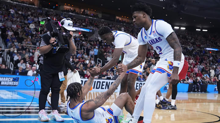 Mar 20, 2025; Providence, RI, USA;  Kansas Jayhawks guard Shakeel Moore (0) is helped up during the first half against Arkansas Razorbacks at Amica Mutual Pavilion. Mandatory Credit: Gregory Fisher-Imagn Images