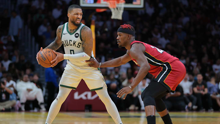Nov 26, 2024; Miami, Florida, USA; Milwaukee Bucks guard Damian Lillard (0) protects the basketball from Miami Heat forward Jimmy Butler (22) during the third quarter at Kaseya Center. Mandatory Credit: Sam Navarro-Imagn Images