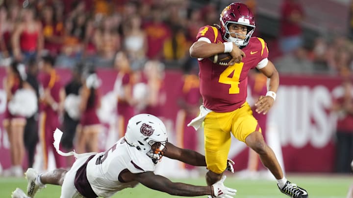 Aug 30, 2025; Los Angeles, California, USA; Southern California Trojans quarterback Husan Longstreet (4) carries the ball against Missouri State Bears cornerback Navonn Barrett (5) in the second half at United Airlines Field at Los Angeles Memorial Coliseum. Mandatory Credit: Kirby Lee-Imagn Images