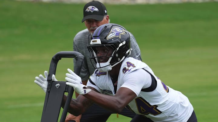 Jul 24, 2025; Owings Mills, MD, USA; Baltimore Ravens coach Chuck Pagano and safety Malaki Starks (24) work on drills during training camp at the Under Armour Performance Center. Mandatory Credit: Mitch Stringer-Imagn Images