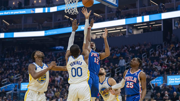 Jan 30, 2024; San Francisco, California, USA;  Philadelphia 76ers forward Tobias Harris (12) shoots a layup against Golden State Warriors forward Jonathan Kuminga (00) during the first quarter at Chase Center. Mandatory Credit: Neville E. Guard-Imagn Images