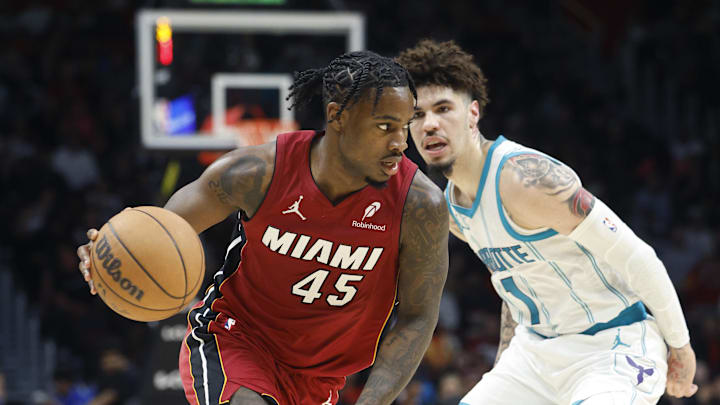 Mar 10, 2025; Miami, Florida, USA;  Miami Heat guard Davion Mitchell (45) brings the ball up court around Charlotte Hornets guard LaMelo Ball (1) during the second half at Kaseya Center. Mandatory Credit: Rhona Wise-Imagn Images