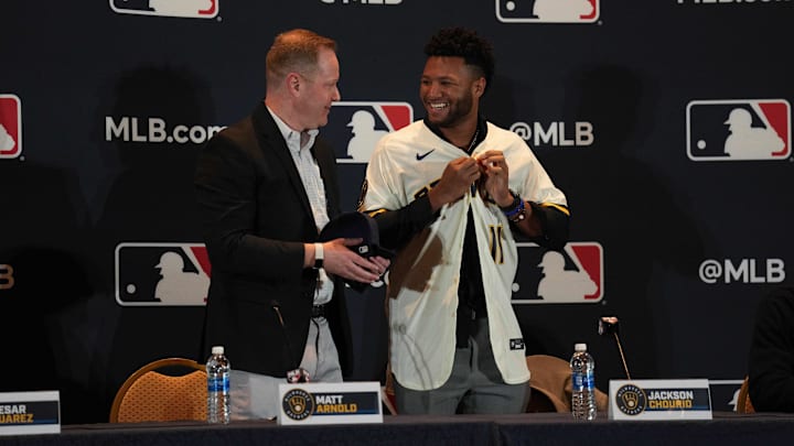 Dec 4, 2023; Nashville, TN, USA; Milwaukee Brewers general manager Matt Arnold presents Jackson Chourio with a team uniform and hat during the MLB 2023 Winter Meetings. Mandatory Credit: Kyle Schwab-Imagn Images