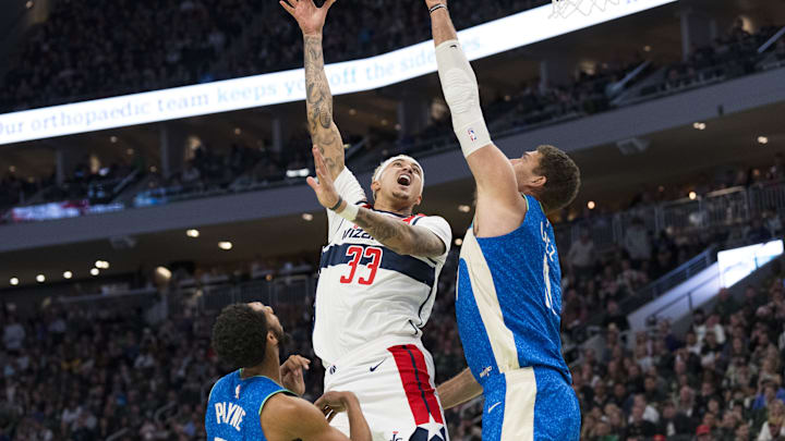 Nov 24, 2023; Milwaukee, Wisconsin, USA; Washington Wizards forward Kyle Kuzma (33) shoots against Milwaukee Bucks center Brook Lopez (11) during the second quarter at Fiserv Forum. Mandatory Credit: Jeff Hanisch-Imagn Images