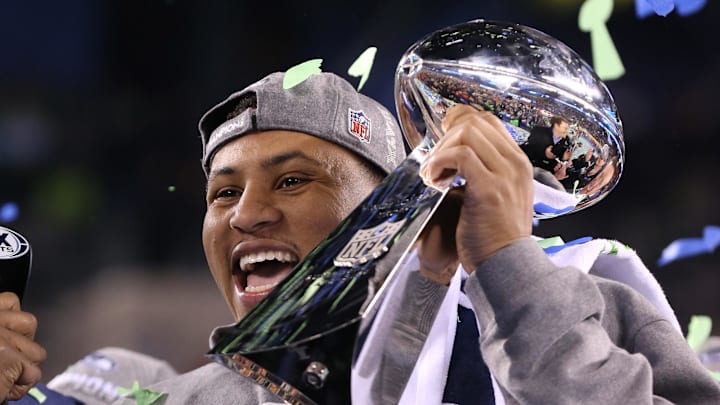 Feb 2, 2014; East Rutherford, NJ, USA; Seattle Seahawks outside linebacker Malcolm Smith (53) is awarded MVP as he hoists the Lombardi Trophy after winning Super Bowl XLVIII against the Denver Broncos at MetLife Stadium. Seattle Seahawks won 43-8. Mandatory Credit: Matthew Emmons-Imagn Images