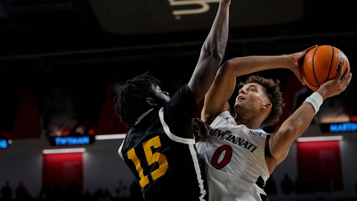 Nov 4, 2024; Cincinnati, OH, USA; Cincinnati Bearcats guard Dan Skillings Jr. (0) drives against Arkansas-Pine Bluff Golden Lions forward Dennis Asoro (15) in the second half of the NCAA mens basketball game between the Cincinnati Bearcats and the Arkansas-Pine Bluff Golden Lions at Fifth Third Arena on the University of Cincinnati campus on Monday, Nov. 4, 2024. The Bearcats won 109-54. Mandatory Credit: Sam Greene/USA TODAY Network via Imagn Images Nov 4, 2024; Cincinnati, OH, USA; Cincinnati Bearcats guard Dan Skillings Jr. (0) drives against Arkansas-Pine Bluff Golden Lions forward Dennis Asoro (15) in the second half of the NCAA mens basketball game between the Cincinnati Bearcats and the Arkansas-Pine Bluff Golden Lions at Fifth Third Arena on the University of Cincinnati campus on Monday, Nov. 4, 2024. The Bearcats won 109-54. Mandatory Credit: Sam Greene/USA TODAY Network via Imagn Images