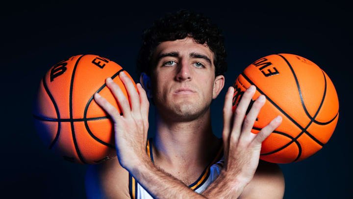 Forward Kyle Evans poses with two basketballs during a UC Irvine photo shoot.