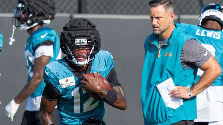 Jacksonville Jaguars wide receiver Travis Hunter (12) runs a drill as Jacksonville Jaguars Defensive Coordinator Anthony Campanile watches during the Jaguars 14th NFL training camp session at Miller Electric Center Tuesday August 12, 2025 in Jacksonville, Fla. The Jaguars travel to New Orleans to play the Saints this Sunday in their second preseason game. [Doug Engle/Florida Times-Union]