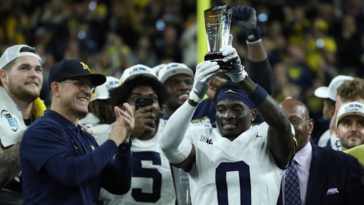 Michigan coach Jim Harbaugh celebrates defensive back Mike Sainristil (0), who was named MVP, after U-M's 26-0 win over Iowa in the Big Ten championship game on Saturday, Dec. 2, 2023.