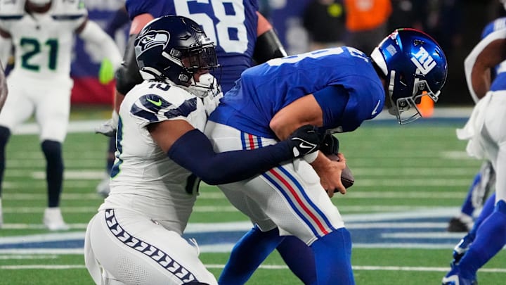 Oct 2, 2023; East Rutherford, New Jersey, USA; New York Giants quarterback Daniel Jones (8) is sacked by Seattle Seahawks linebacker Uchenna Nwosu (10) in the second half at MetLife Stadium. Mandatory Credit: Robert Deutsch-Imagn Images