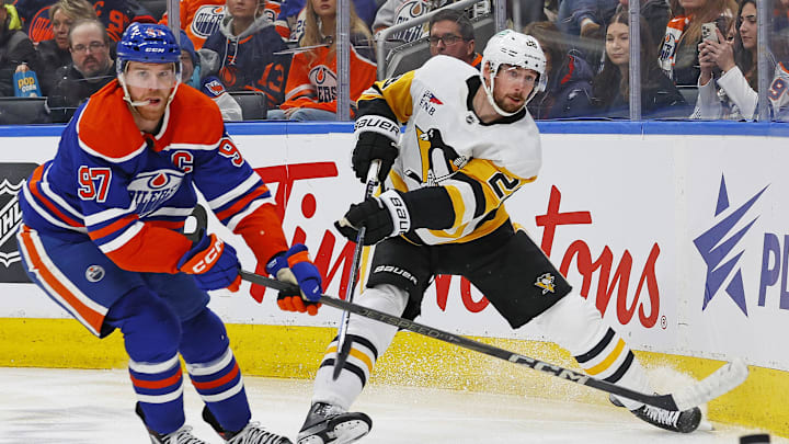 Mar 3, 2024; Edmonton, Alberta, CAN; Pittsburgh Penguins defensemen Marcus Pettersson (28) clears the puck in front of Edmonton Oilers forward Connor McDavid (97) during the third period at Rogers Place. Mandatory Credit: Perry Nelson-Imagn Images