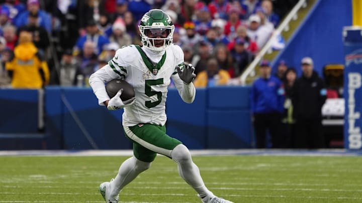 Dec 29, 2024; Orchard Park, New York, USA; New York Jets wide receiver Garrett Wilson (5) runs with the ball after making a catch against the Buffalo Bills during the second half at Highmark Stadium. Mandatory Credit: Gregory Fisher-Imagn Images