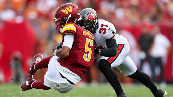 Sep 8, 2024; Tampa, Florida, USA; Washington Commanders quarterback Jayden Daniels (5) is hit by Tampa Bay Buccaneers safety Antoine Winfield Jr. (31) in the second quarter at Raymond James Stadium. Mandatory Credit: Nathan Ray Seebeck-Imagn Images