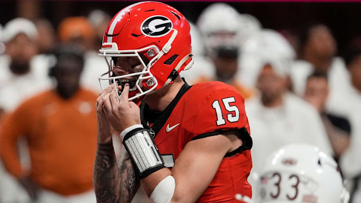 Georgia quarterback Carson Beck (15) putts in his mouth grad on the final play during overtime of the SEC championship game against Texas in Atlanta, on Saturday, Dec. 7, 2024.