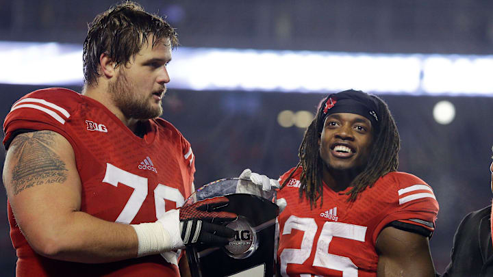 Wisconsin Badgers offensive lineman Rob Havenstein (78), and Wisconsin Badgers running back Melvin Gordon (25) hold the Big Ten West Division trophy Athletic Director Barry Alvarez and coach Gary Anderson watch. Wisconsin beat Minnesota 34-24 to advance to Big Ten Championship