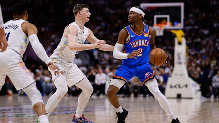 May 15, 2025; Denver, Colorado, USA; Oklahoma City Thunder guard Shai Gilgeous-Alexander (2) controls the ball as Denver Nuggets guard Christian Braun (0) guards in the second quarter during game six of the second round for the 2025 NBA Playoffs at Ball Arena. Mandatory Credit: Isaiah J. Downing-Imagn Images