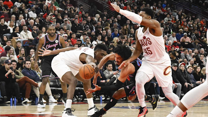 Dec 17, 2025; Chicago, Illinois, USA;  Chicago Bulls guard Tre Jones (30) drives to the basket against Cleveland Cavaliers center Thomas Bryant (3) and guard Donovan Mitchell (45) during the second half at United Center. Mandatory Credit: Matt Marton-Imagn Images
