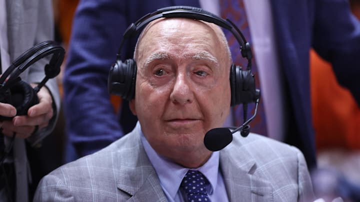 ESPN analyst Dick Vitale sits at the media table during a game.