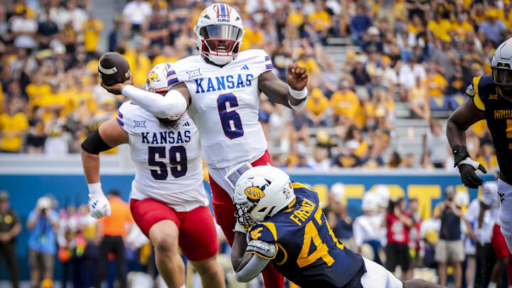 Sep 21, 2024; Morgantown, West Virginia, USA; Kansas Jayhawks quarterback Jalon Daniels (6) releases a pass while being pressured by West Virginia Mountaineers linebacker Ty French (47) during the second quarter at Mountaineer Field at Milan Puskar Stadium. Mandatory Credit: Ben Queen-Imagn Images Sep 21, 2024; Morgantown, West Virginia, USA; Kansas Jayhawks quarterback Jalon Daniels (6) releases a pass while being pressured by West Virginia Mountaineers linebacker Ty French (47) during the second quarter at Mountaineer Field at Milan Puskar Stadium. Mandatory Credit: Ben Queen-Imagn Images