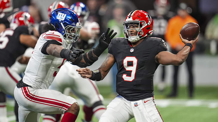 Dec 22, 2024; Atlanta, Georgia, USA; Atlanta Falcons quarterback Michael Penix Jr. (9) passes under pressure from New York Giants linebacker Kayvon Thibodeaux (5) during the first quarter at Mercedes-Benz Stadium. Mandatory Credit: Dale Zanine-Imagn Images